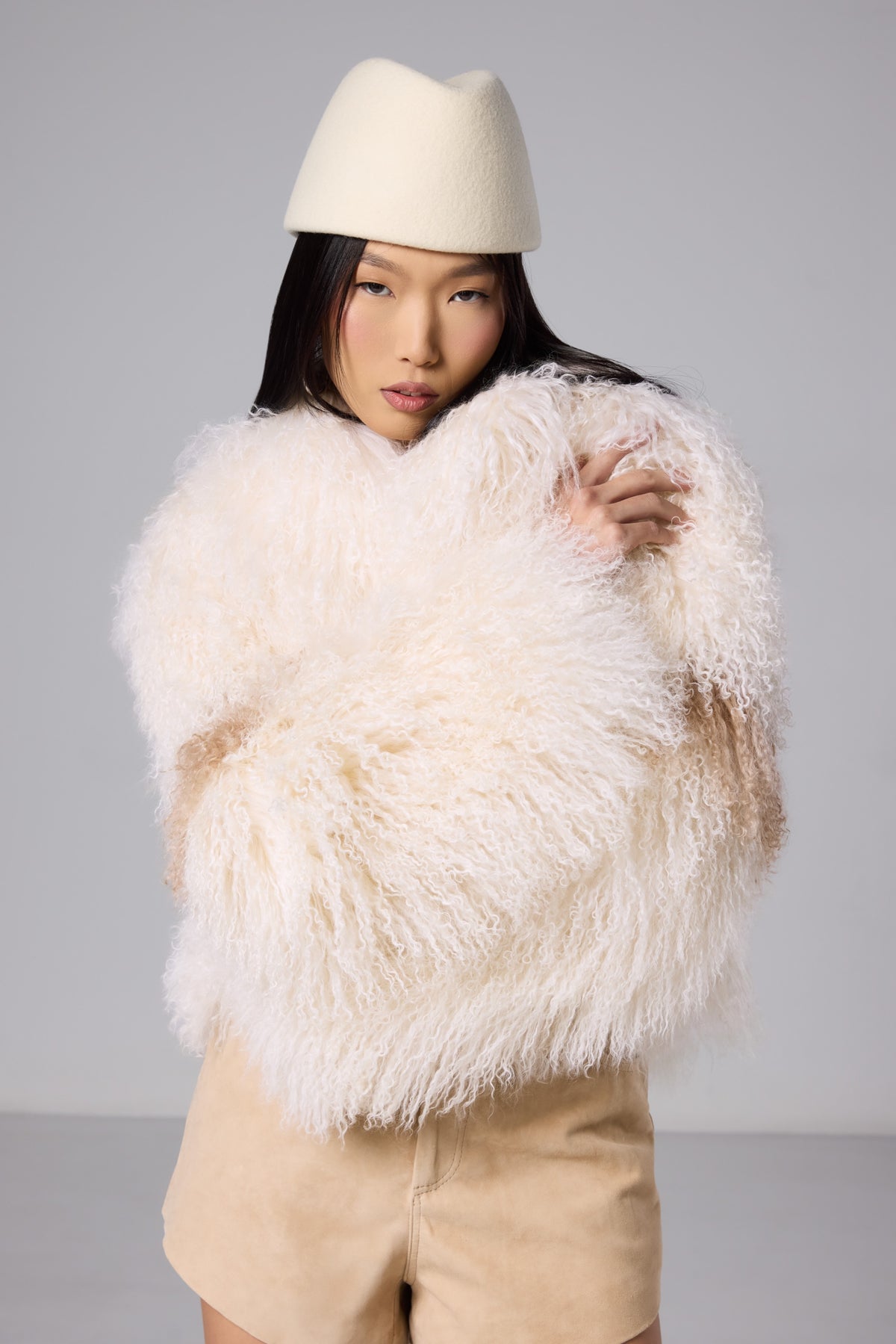 Close-up of the ivory Mongolian fur texture and sleeve on the Nola coat